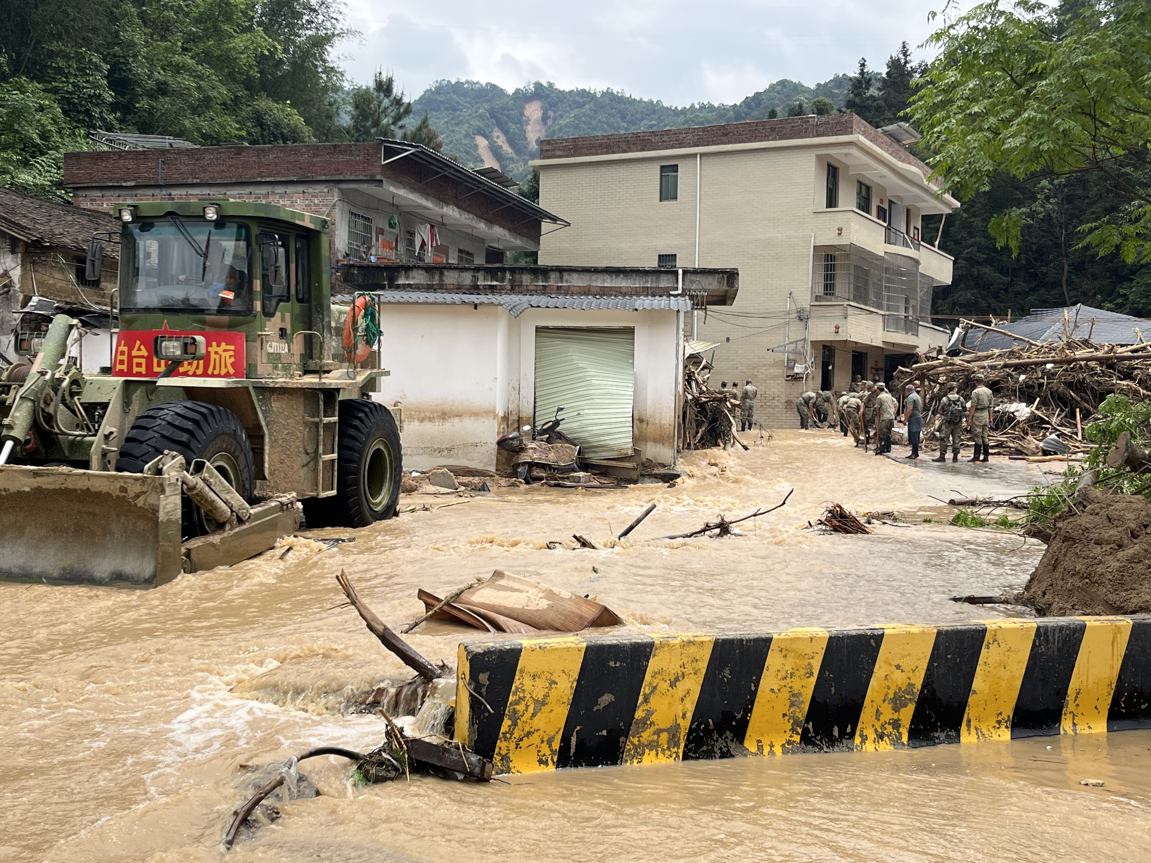 江湾镇街区入口处，洪水漫过318县道，给救援造成阻碍。  吴绵强 摄